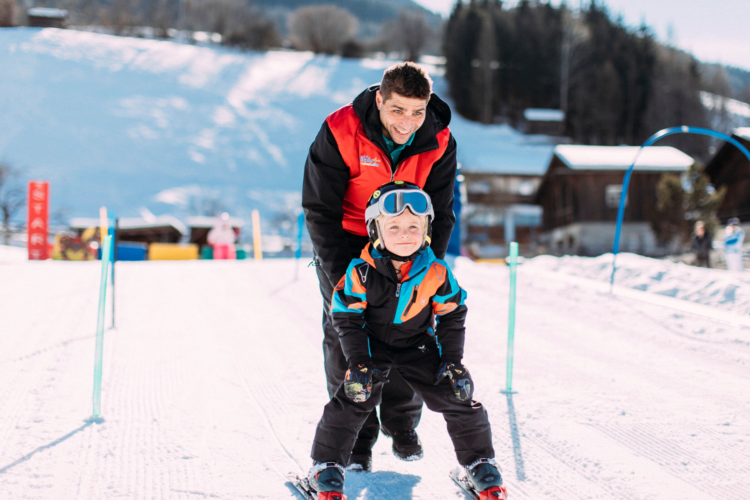 Erwachsener und Kind beim Skifahren auf schneebedecktem Hang in Tirol.