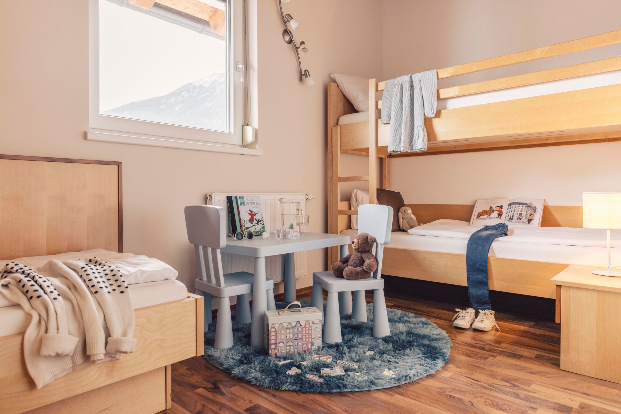 Das Kinderzimmer mit einem Basteltisch und einem Etagenbett in der Pitzisuite