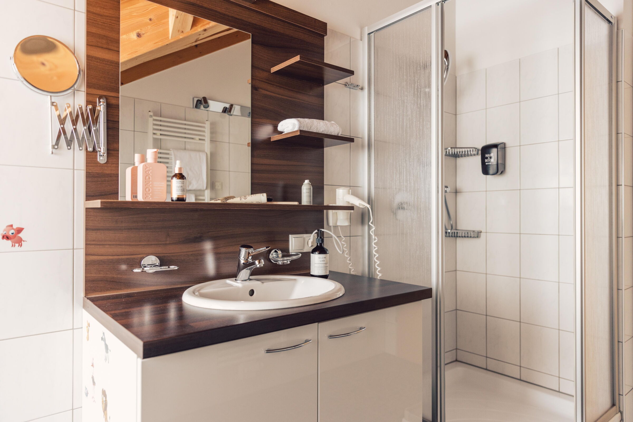 Modernes Badezimmer mit Holzdetails, Waschbecken und geräumiger Dusche.