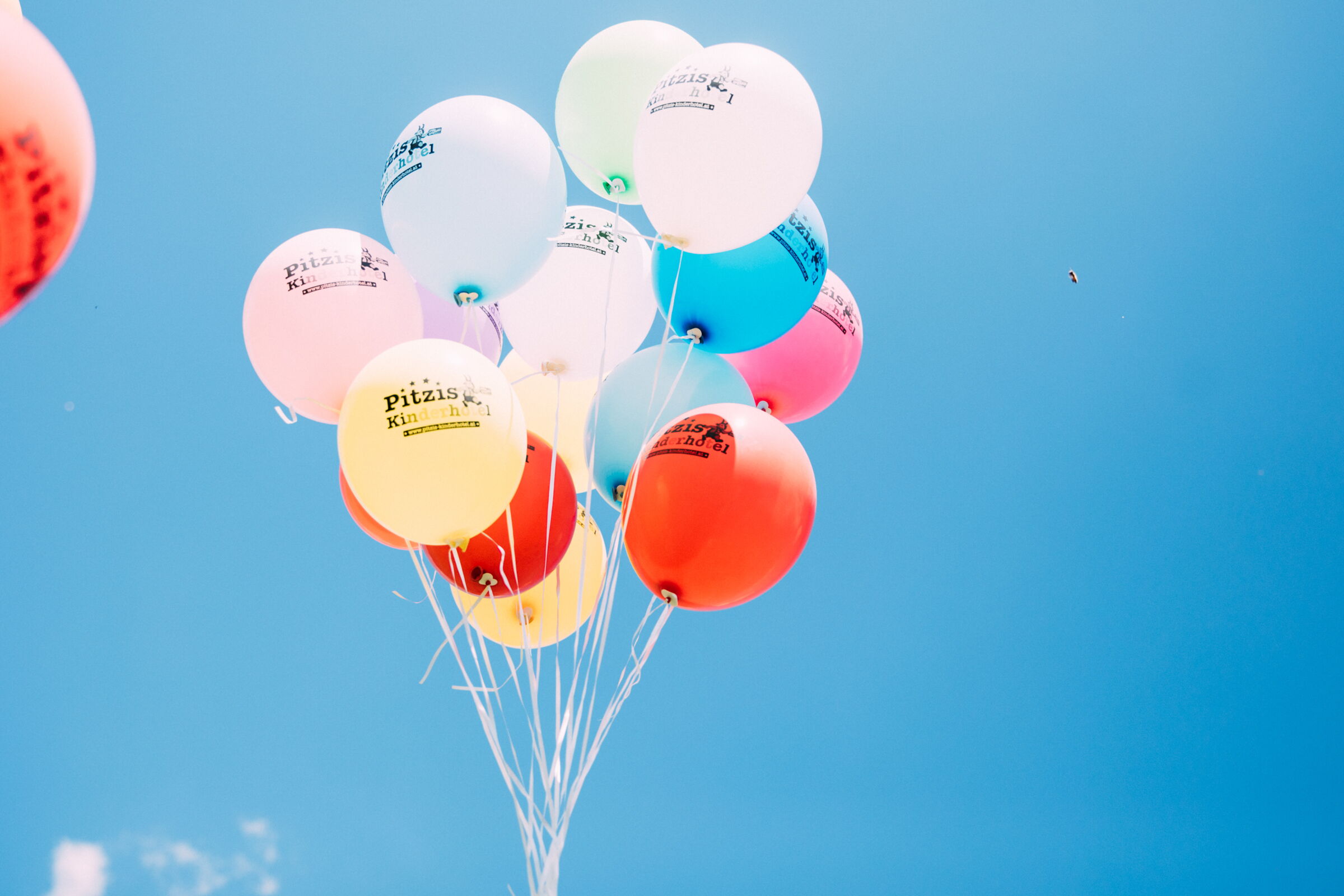 Viele bunte Luftballons vor klarem, blauem Himmel.