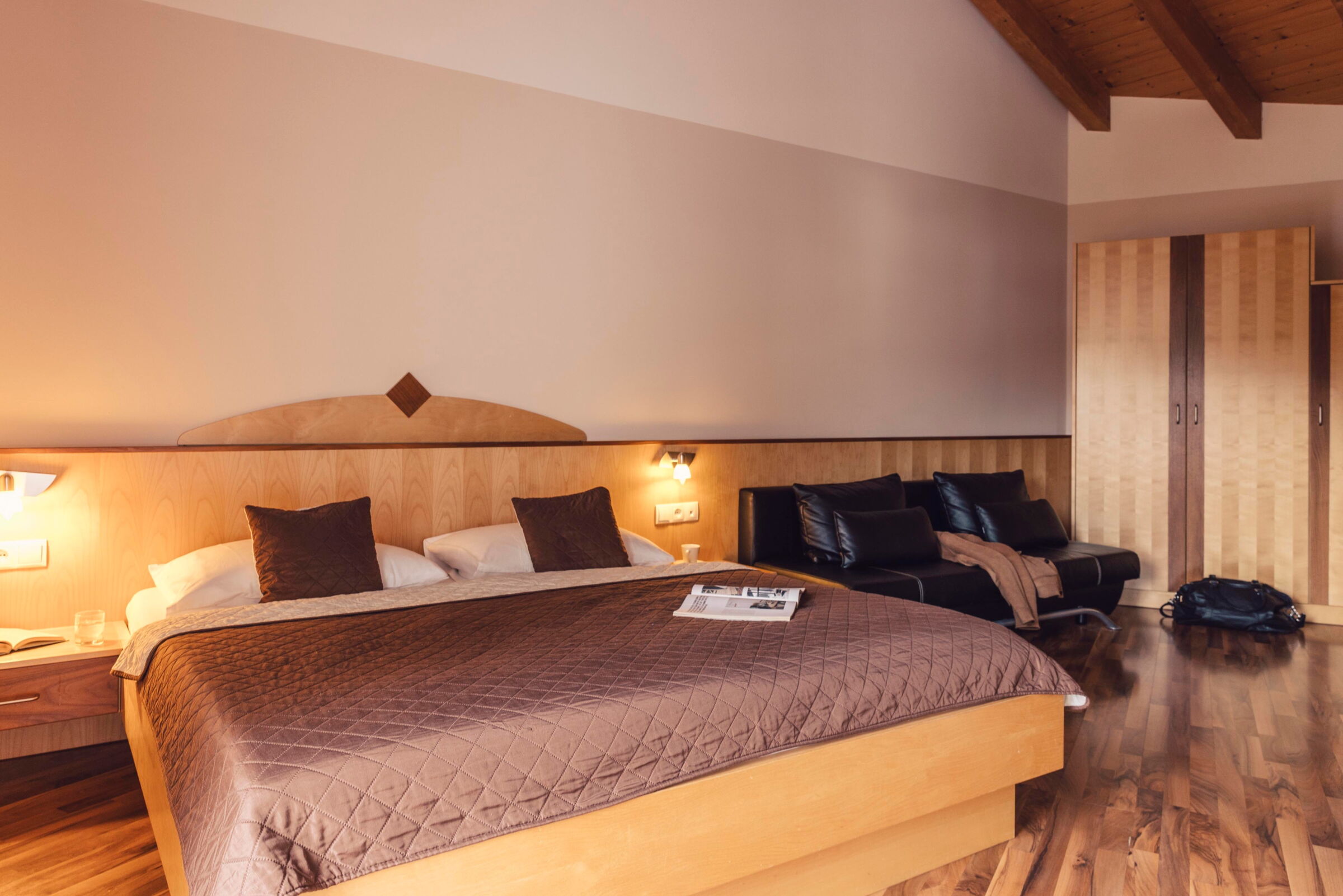 Gemütliches Schlafzimmer mit Holzakzenten und weichen Kissen im Pitzis Kinderhotel.