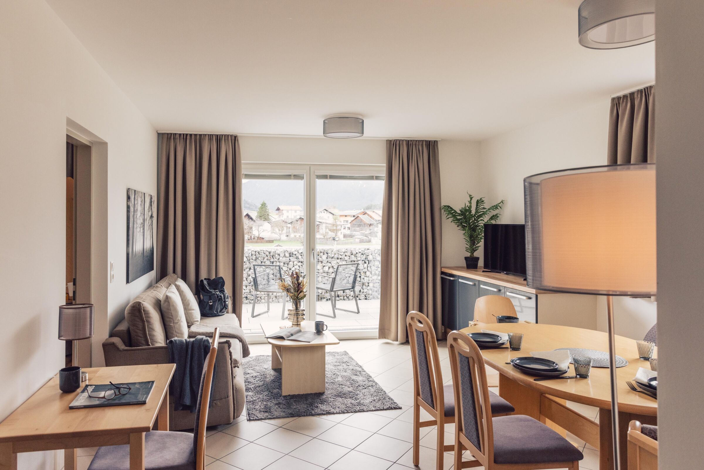 Gemütliches Wohnzimmer mit Balkon und Blick auf die Tiroler Alpen.