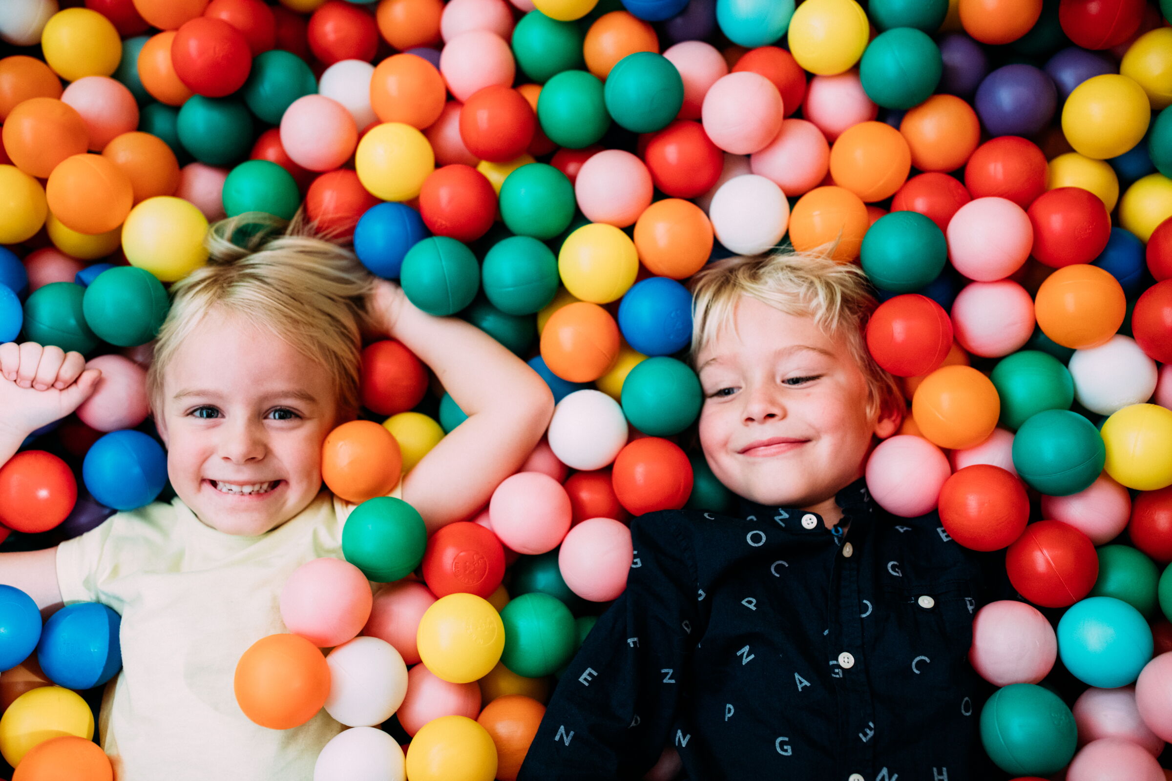 Kinder die im Pitzis Kinderhotel in Tirol im Bällebad liegen