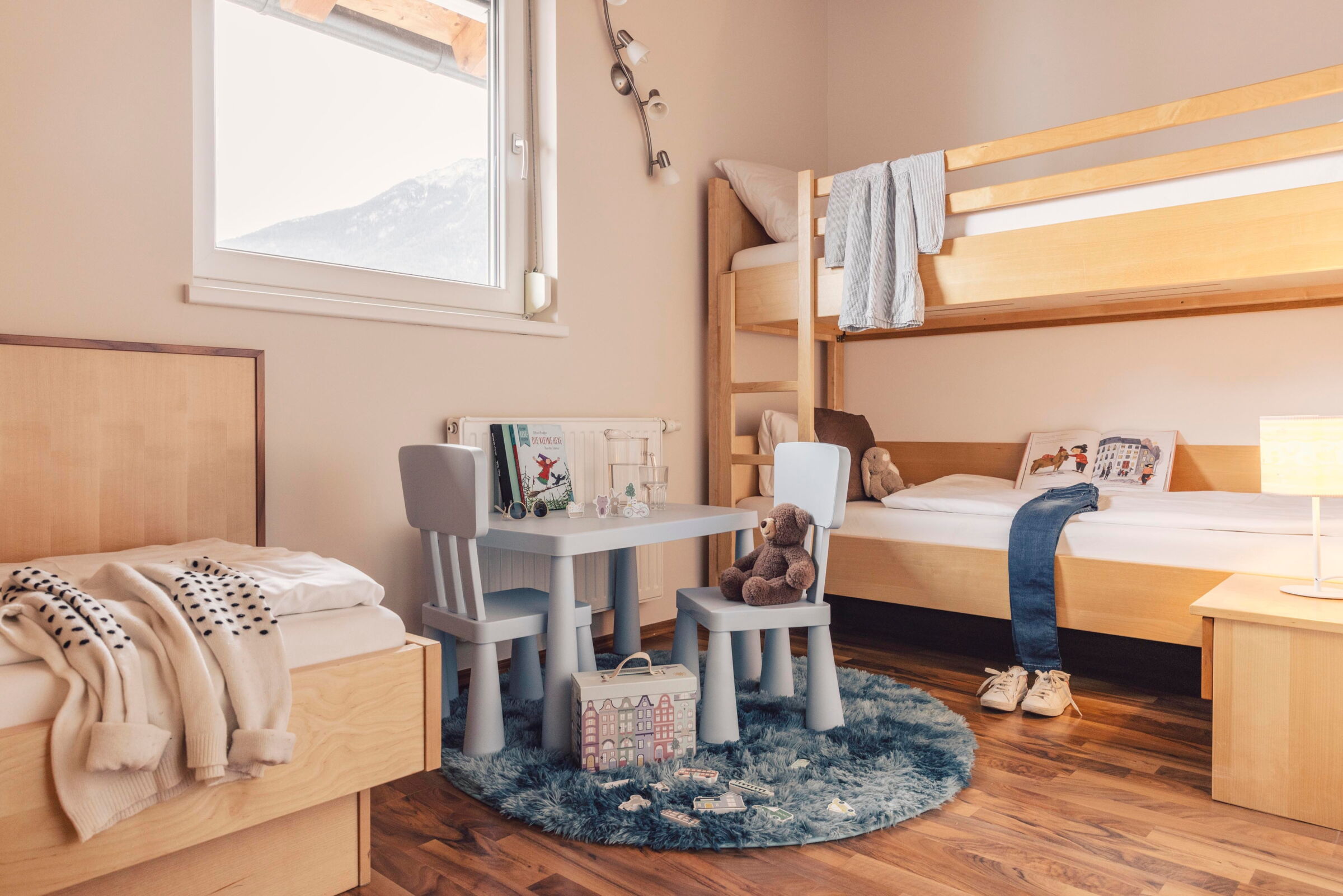 Das Kinderzimmer mit einem Basteltisch und einem Etagenbett in der Pitzisuite