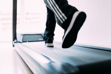 Person auf Laufband in heller Umgebung beim Training.
