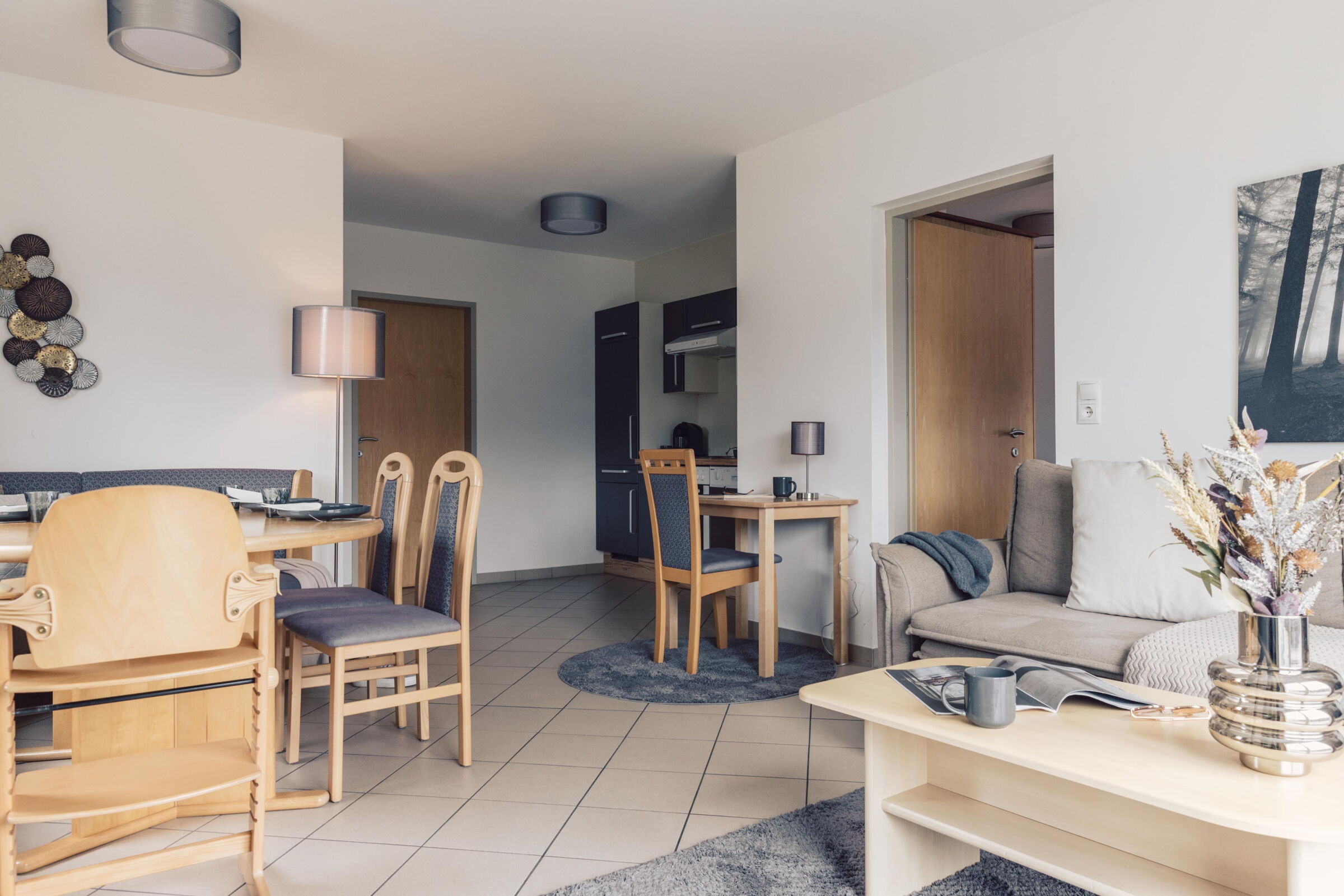 Bright family suite with wooden furniture, cozy sitting area and modern dining area.