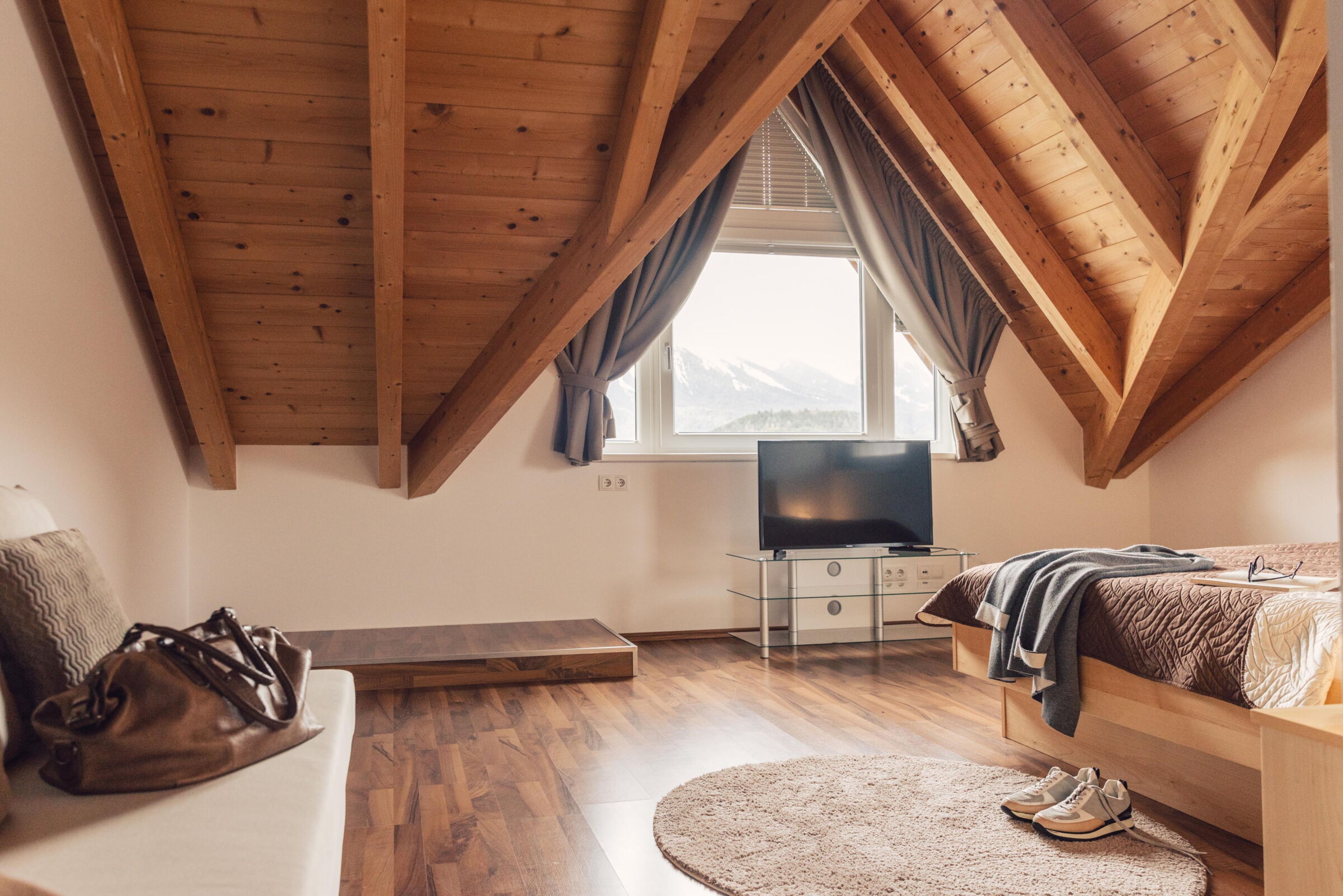 Top floor apartment with wooden beams, sofa, TV and mountain view